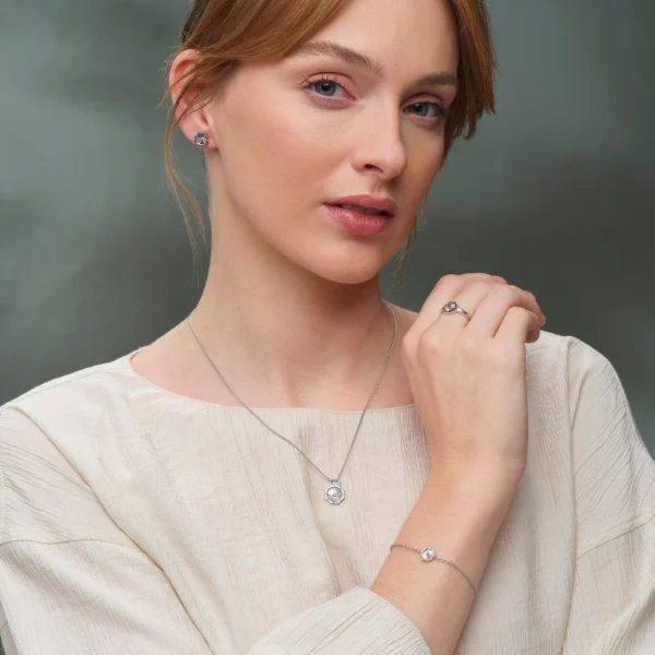 a woman wearing a white shirt and necklace