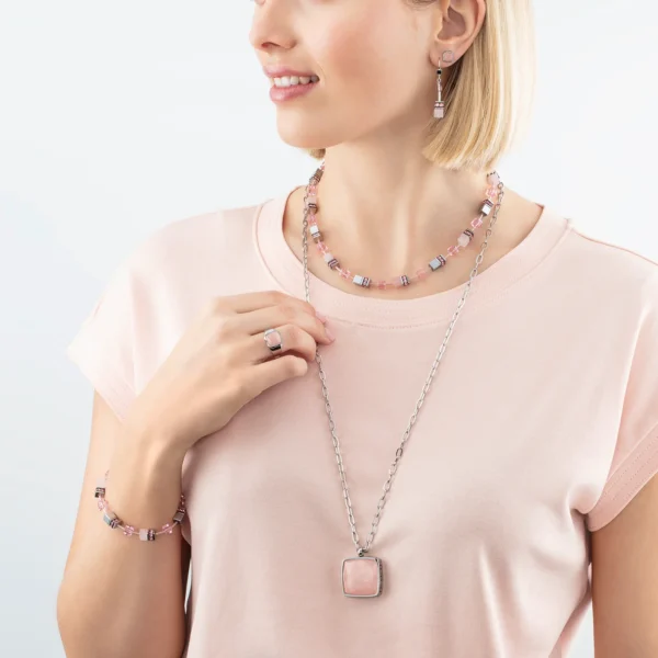 a woman wearing a pink shirt and necklace