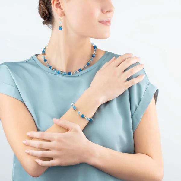 a woman wearing a blue necklace and earrings